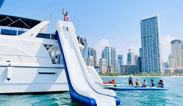 Tourists play ride & slide on a yacht rental in Dubai